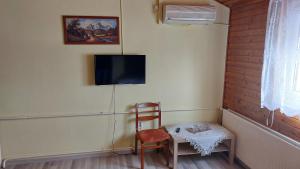 瓦茨纳苏加尔旅馆的配有桌子、椅子和电视的房间