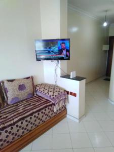 阿加迪尔Appartement agadir centre的一间墙上配有电视的沙发客房
