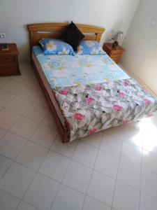 阿加迪尔Appartement agadir centre的卧室内的一张带被子和枕头的床