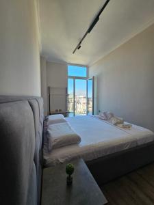 地拉那Sky Apartaments city center的一间卧室设有两张床和大窗户