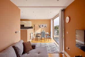 泰晤士河畔金斯顿Charming One-Bedroom Retreat in Kingston KT2, London的客厅配有沙发和桌子