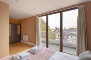 泰晤士河畔金斯顿Charming One-Bedroom Retreat in Kingston KT2, London的一间卧室设有一张床和一个大窗户