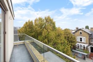 泰晤士河畔金斯顿Charming One-Bedroom Retreat in Kingston KT2, London的阳台享有树木和建筑的景致。