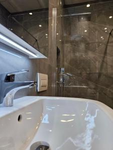 地拉那Sky Apartaments city center的浴室配有白色浴缸和淋浴。