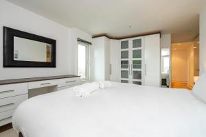 伦敦Borough Flat with City Views by UnderTheDoormat的白色的卧室配有一张白色的大床和电视。