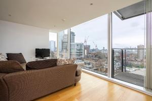 伦敦Borough Flat with City Views by UnderTheDoormat的带沙发和大窗户的客厅