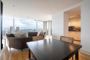 伦敦Borough Flat with City Views by UnderTheDoormat的厨房以及带桌椅的用餐室。