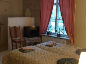 瓦尔考斯Nostalginen residenssi Taika的一间卧室设有两张床、一台电视和一扇窗户。