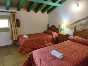 埃尔韦鲁埃科卡斯蒂略住宿酒店的一间卧室配有两张红色床单