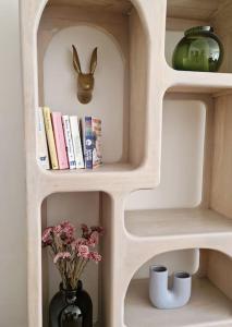 菲尔福尔德Gezellig appartement in Vilvoorde的书架,花瓶和兔子