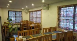 博卡拉Hotel Suite Inn Lodge的一间空的教室,里面设有桌椅和窗户