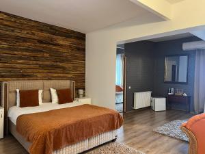 德瓦Hanu lu Mos Opinca的一间卧室设有一张床和木墙