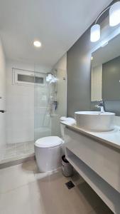 圣佩德罗苏拉Stylish Condo In Tribeca的浴室配有卫生间、盥洗盆和淋浴。