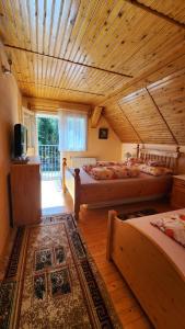 帕迪斯Casa de vacanta Julius的一间卧室设有两张床和木制天花板