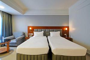 海得拉巴Palette - Madhapur的酒店客房,配有两张床和椅子