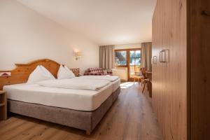 费尔兹姆斯Hotel am Sonnenhügel的酒店客房设有一张大床和一张书桌。
