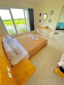 普拉亚TANAWU AIRPORT HOTEL LOMBOK的一间卧室设有一张大床和大窗户