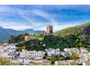 卡索拉Hotel Rural Cazorla Posada del Cordobés的山丘上的小镇,上面有城堡