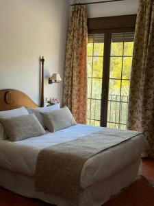 卡索拉Hotel Rural Cazorla Posada del Cordobés的一间卧室设有一张大床和一个大窗户