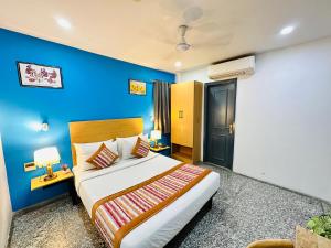 新德里Hotel Golden Saffron - Punjabi Bagh Delhi的一间卧室设有一张蓝色墙壁的大床