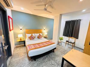 新德里Hotel Golden Saffron - Punjabi Bagh Delhi的酒店客房,配有一张床、一张桌子和椅子