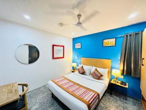 新德里Hotel Golden Saffron - Punjabi Bagh Delhi的一间卧室设有一张床和蓝色的墙壁