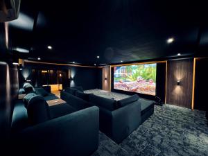 沙迦AL JUNAIDI FARM BY BRIDGE RETREATS的电影室配有沙发和平面电视