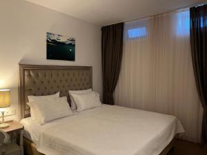 阿拉恰特阿拉恰特布拉马索乐精品酒店的一间卧室配有一张带白色床单的床和一扇窗户。