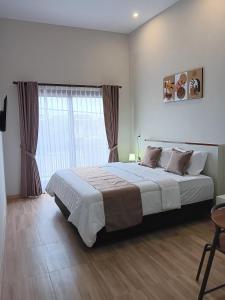普禾加多44 Guest House Syariah的一间卧室设有一张大床和一个窗户。