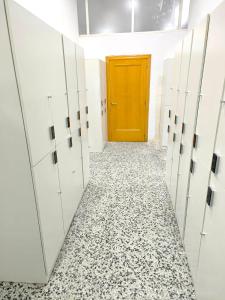 瓦伦西亚CAPSULE INN VALENCIA Hostel的走廊上设有白色储物柜和黄色门
