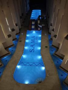 赫尔格达SAMA Beach Resort的地板上设有蓝色灯光的游泳池