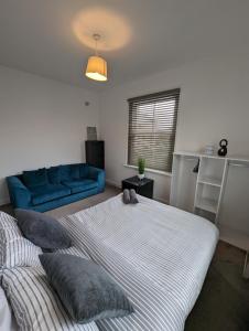 格雷夫森德2 bedroom apartment in Gravesend 10 mins walk from train station with free parking的一间卧室配有两张床和蓝色的沙发