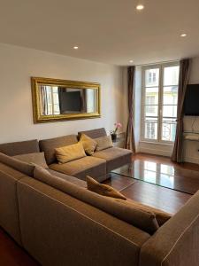 圣日耳曼昂莱bel appartement chic et cosy 78100的客厅配有棕色的沙发和镜子