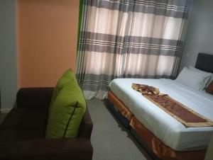 内罗毕Maple Inn Hotel的一间卧室配有一张床、一张沙发和一个窗口