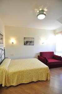 拉拉斯特里拉阿罗索蒂略公寓式酒店的一间卧室配有一张床和一张红色的沙发