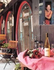 吕德斯海姆林德沃特酒店的一张桌子,上面放着一瓶葡萄酒和一个女人