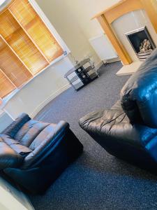莱斯特Instant Lodge的客厅配有真皮沙发和椅子