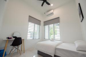 大山脚De Luma(The Rumah) @ Alma 8 bedroom/8 bathroom的一间带白色墙壁的卧室和一张带风扇的床