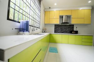 大山脚De Luma(The Rumah) @ Alma 8 bedroom/8 bathroom的厨房设有黄色和白色的橱柜和窗户。