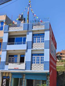 PanepaAraniko homestay的蓝色和白色的建筑,前面有标志
