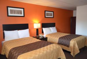 恩菲尔德恩菲尔德酒店的橙色墙壁的酒店客房内的两张床