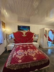 斯维诺乌伊希切Willa Aurelcia的一间卧室配有一张大床和红色的床罩
