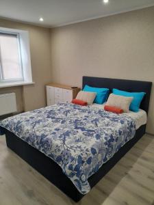 陶格夫匹尔斯Kandavas Apartments的卧室配有蓝色和白色的床和枕头