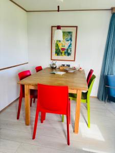 米茨兰Chalet Kocky的一张带红色和绿色椅子的餐桌