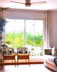 维拉VERALID Gran terraza, Wi Fi y AC en Puerto Rey的客厅配有两把椅子和大窗户