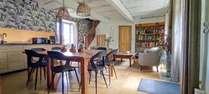 Saint-CybranetLa Source的厨房以及带木桌和椅子的用餐室。