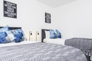 布里奇沃特K Suites - Shetland Court的一间卧室配有两张带蓝白色枕头的床