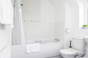 布里奇沃特K Suites - Shetland Court的白色的浴室设有浴缸和卫生间。