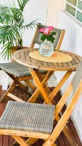 圣胡安Cozy Beach Apartment的一张带一碗鲜花和两把椅子的木桌