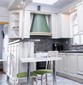 OrestiadaKouros Cozy Home的厨房配有白色橱柜和绿色天花板